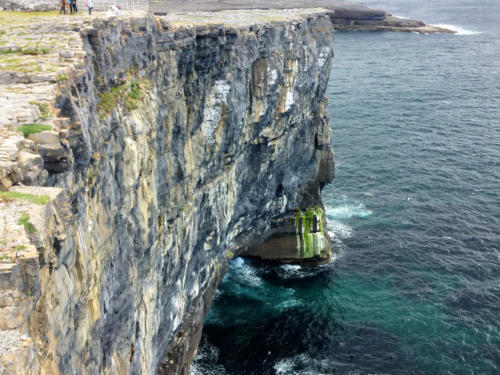 A tall limestone sea cliff above deep green-blue water