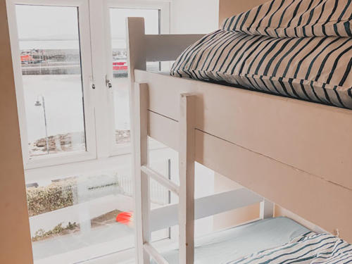 A bunk bed beside a window with a view of the harbour